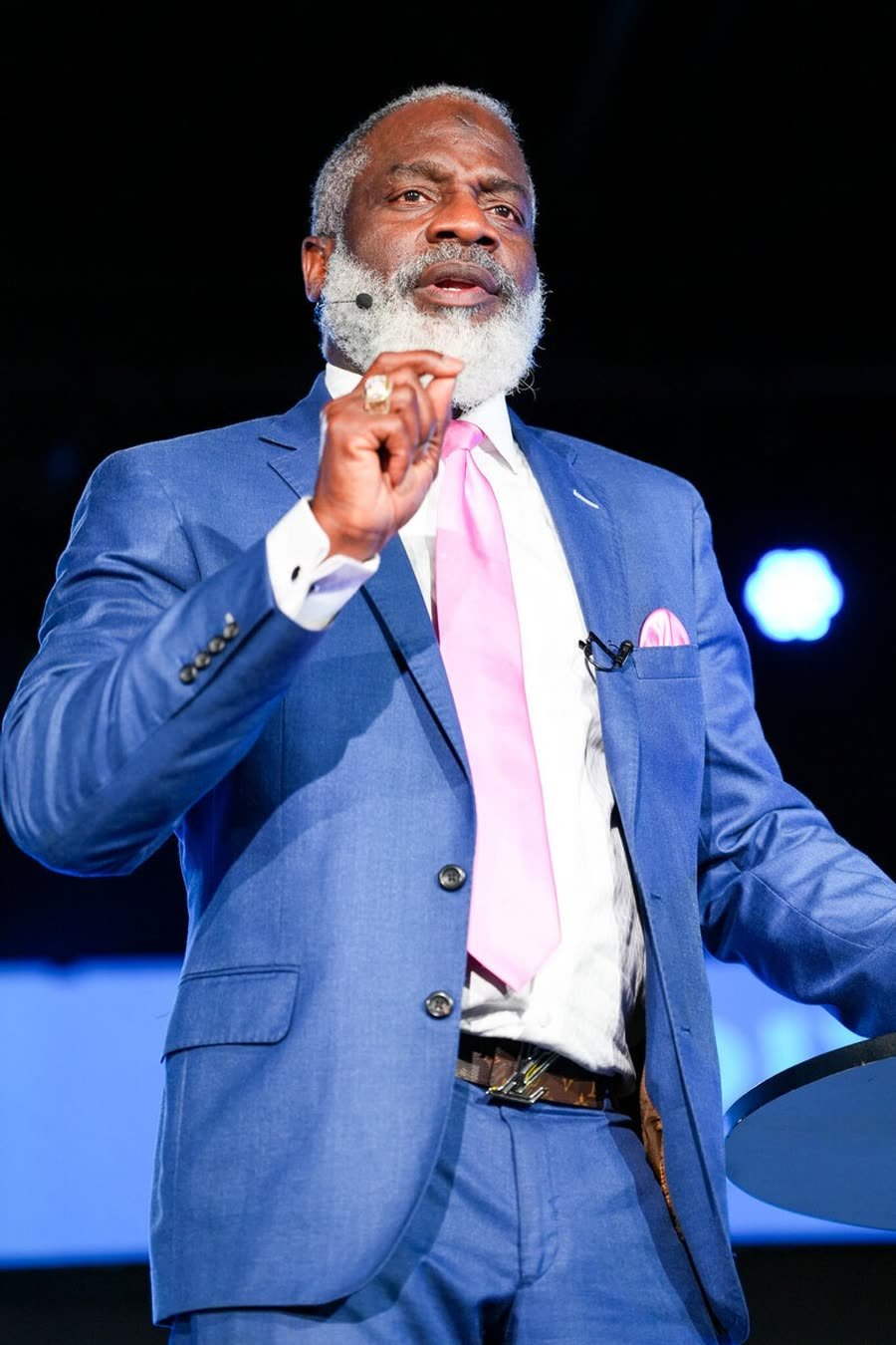 Myron Golden teaching live on stage in a blue suit